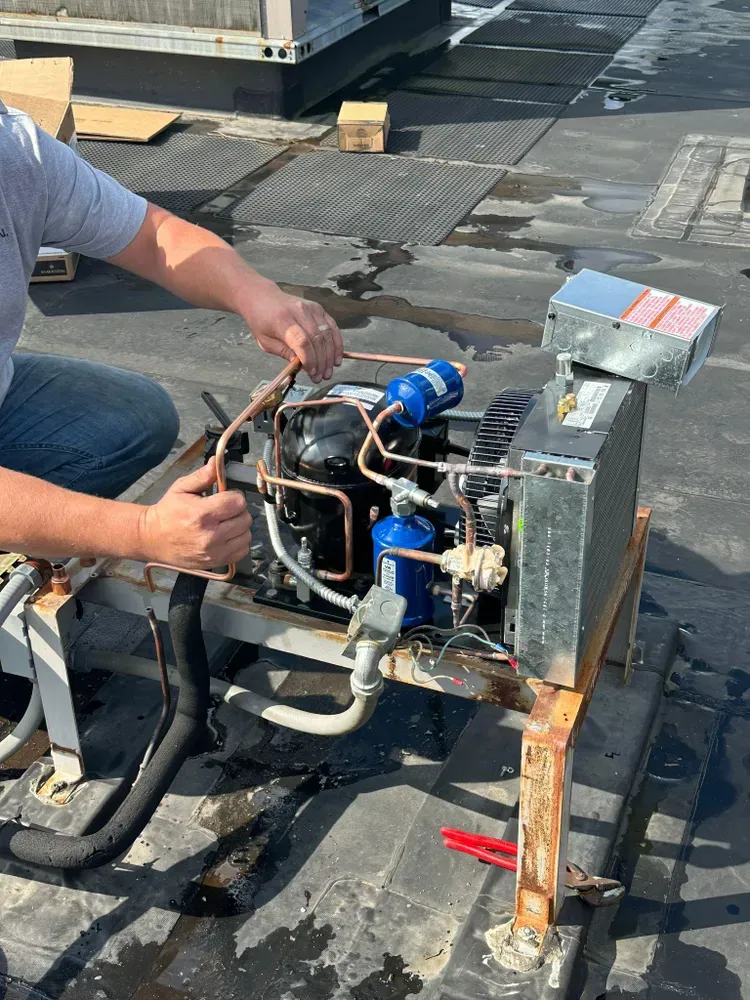 Horizon HVAC technician repairing a rooftop condensing unit