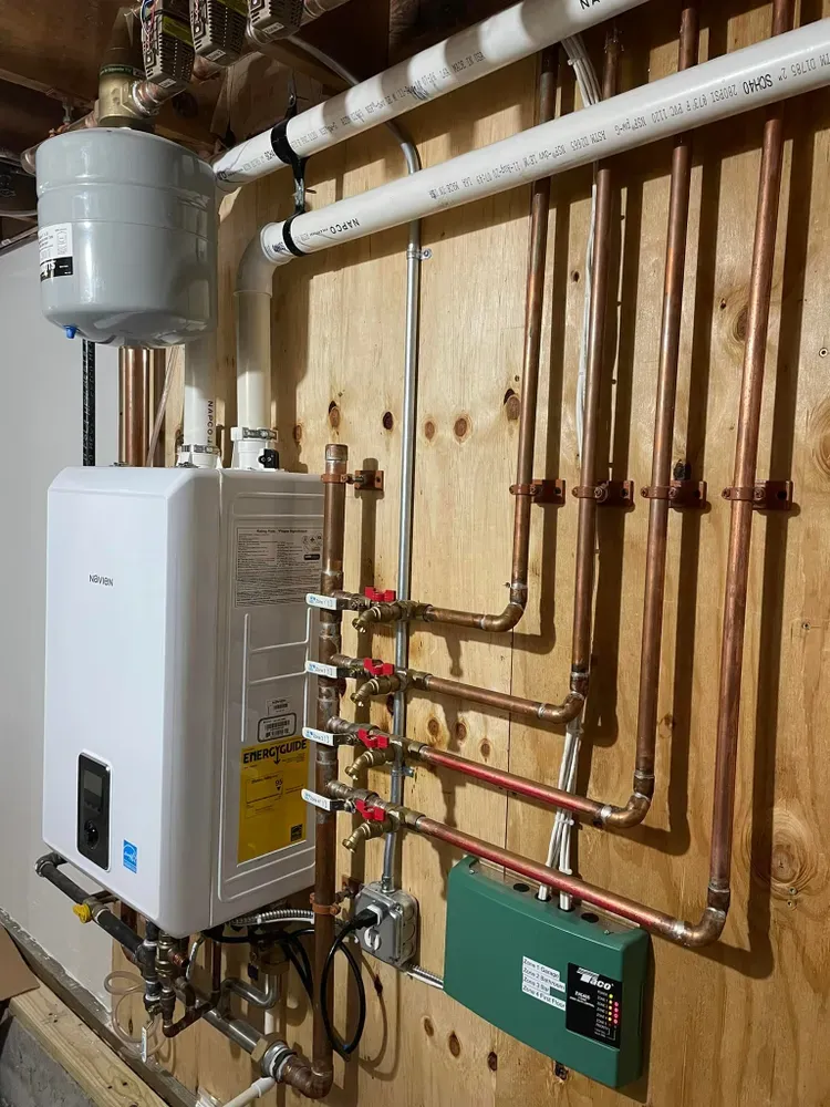 Navien tankless water heater installed by Horizon HVAC with a four-zone copper manifold